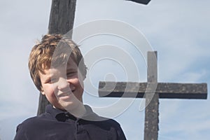 Smiling Autistic Boy in Front of a Cross