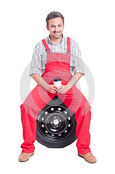 Smiling auto mechanic having a coffee break