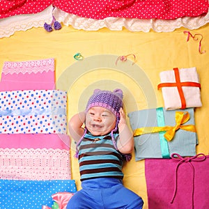 Smiling baby boy celebrate his first birthday and enjoy his gifts