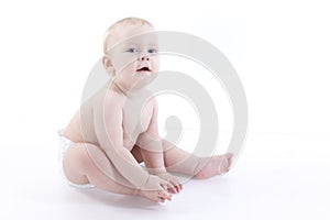 Smiling baby-boy in a diaper sitting on the floor