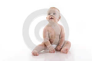Smiling baby-boy in a diaper sitting on the floor