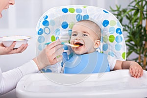 Smiling baby boy enjoy at feeding time