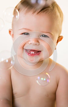 Smiling baby with bubbles