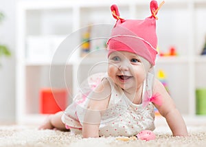 Smiling baby child crawling on nursery floor