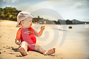 Smiling baby child kid leisure activity beach playing sand sea during hot summer holidays