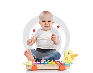 Smiling baby child playing metallophone