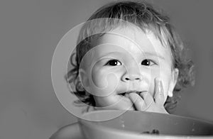 Smiling baby eating food. Healthy nutrition for kids. Funny child face closeup.