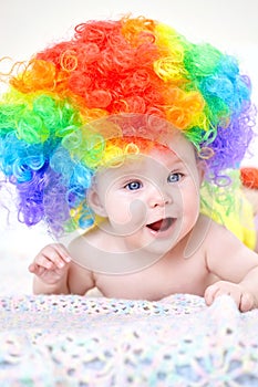 Smiling baby girl with colorful wig