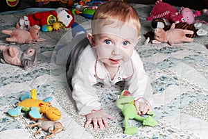 Smiling baby girl on the floor with toys