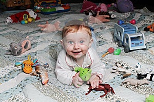 Smiling baby girl on the floor with toys