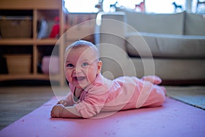 Smiling Baby Girl Lying Down on a Pink Rug