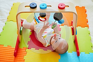 Smiling baby girl lying on play mat