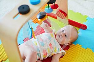 Smiling baby girl lying on play mat