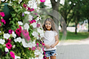 Smiling baby girl walks in the park in bright colors