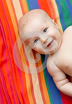 Smiling baby lying on striped background