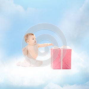 Smiling baby with present on the cloud