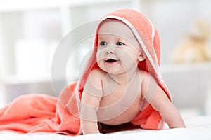 Smiling baby after shower or bath with towel on head