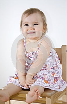 Smiling baby sitting on the chair