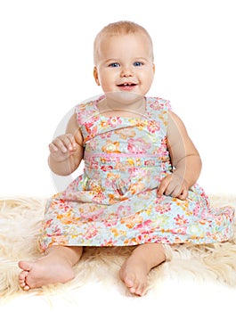 Smiling baby sitting on the furry rug