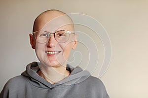 Smiling bald woman in glasses struggle with oncology look at camera. Hairless cancer sick female patient after