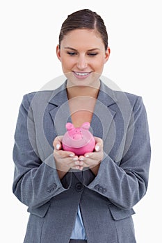 Smiling bank clerk with piggy bank