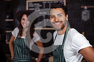 Smiling baristas looking at the camera