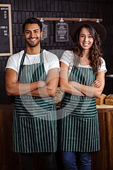 Smiling baristas standing with arms crossed