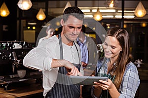 Smiling baristas using tablet