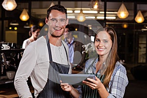 Smiling baristas using tablet