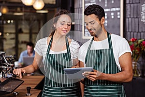 Smiling baristas using tablet