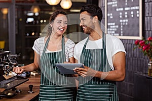 Smiling baristas using tablet