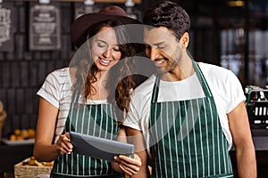 Smiling baristas using tablet