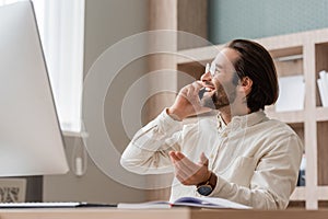 smiling bearded businessman in eyeglasses gesturing