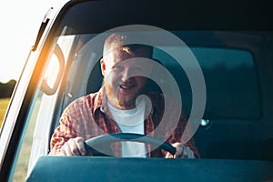 Smiling bearded driver driving his car