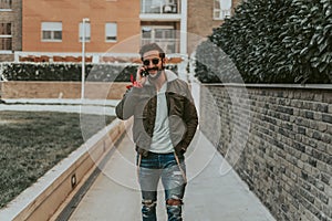 Smiling, bearded man talking on the phone while walking