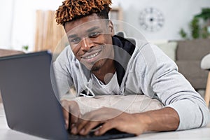 smiling bearded man using laptop at home