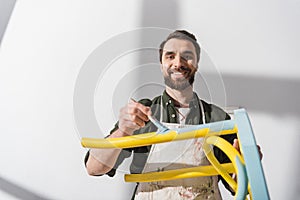 Smiling bearded restorer looking at camera