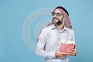Smiling bearded young arabian muslim man in keffiyeh kafiya ring igal agal 3d imax glasses isolated on pastel blue