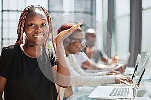 Smiling beautiful African American woman working in call center with diverse team