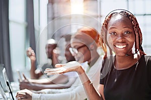 Smiling beautiful African American woman working in call center with diverse team