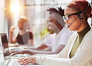 Smiling beautiful African American woman working in call center with diverse team