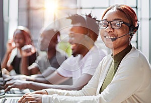 Smiling beautiful African American woman working in call center with diverse team