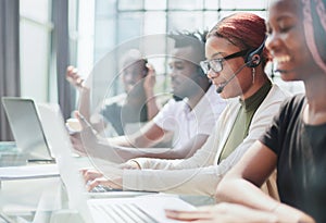 Smiling beautiful African American woman working in call center with diverse team