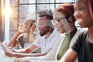 Smiling beautiful African American woman working in call center with diverse team