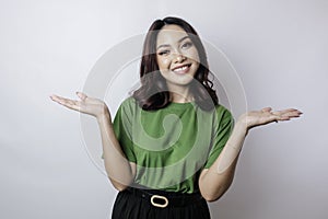 Smiling beautiful Asian woman pointing finger sideward to empty space isolated white background