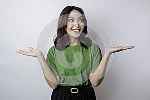 Smiling beautiful Asian woman pointing finger sideward to empty space isolated white background