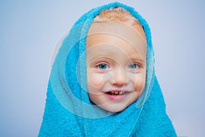 Smiling beautiful baby bathing under a shower at home. Little baby washing with a bubbles in bath in a hat. Happy bath