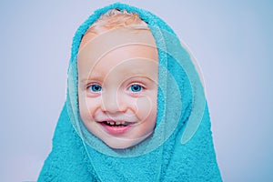 Smiling beautiful baby bathing under a shower at home. Little baby washing with a bubbles in bath in a hat. Happy bath