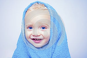 Smiling beautiful baby bathing under a shower at home. Little baby washing with a bubbles in bath in a hat. Happy bath