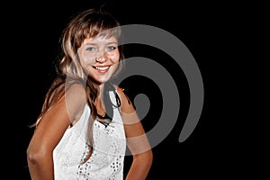Smiling beautiful blue-eyed blonde girl in white dress on a black background